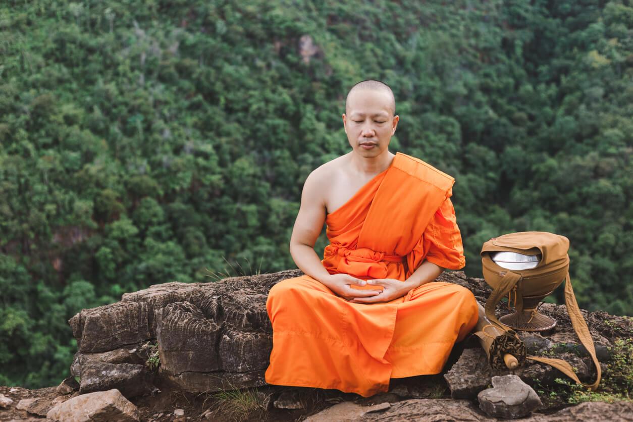 Monk meditating on top of a mountain