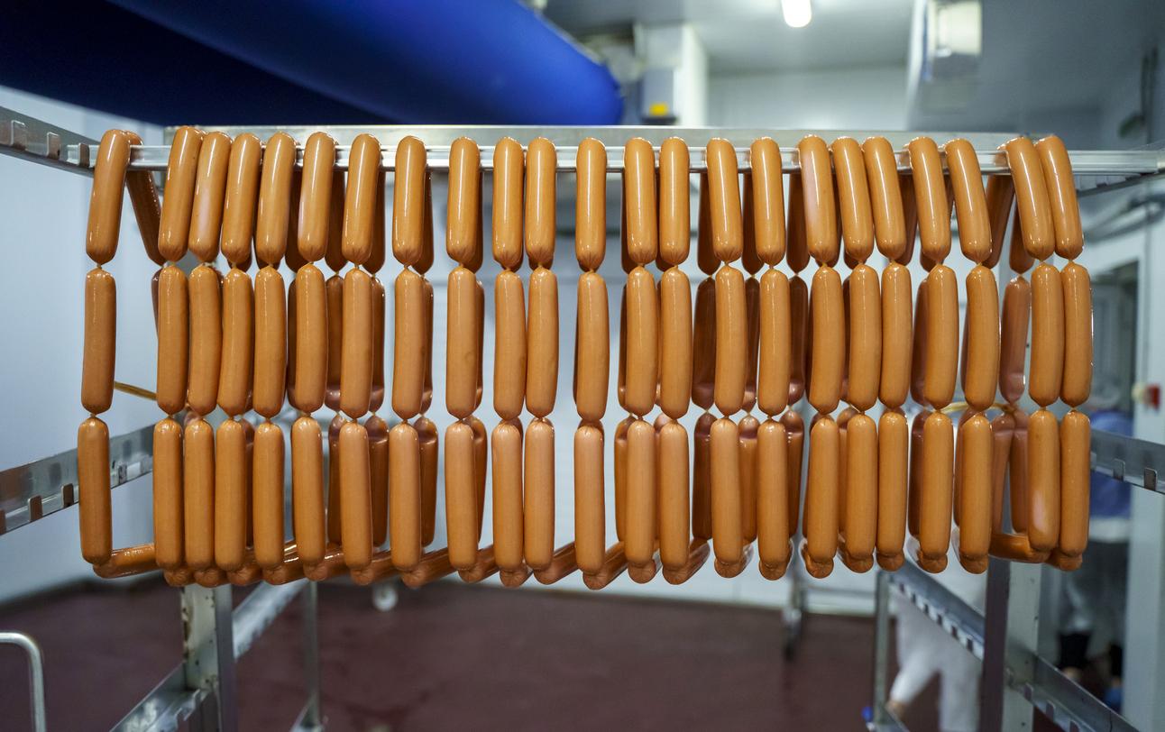 Hot dogs hanging in a factory