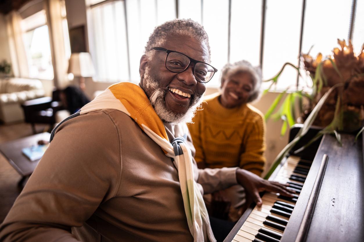 Portrait of a mature man playing piano with his wife at home